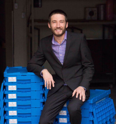 DLO office moving experts - Jesse Meyer sitting on blue bins